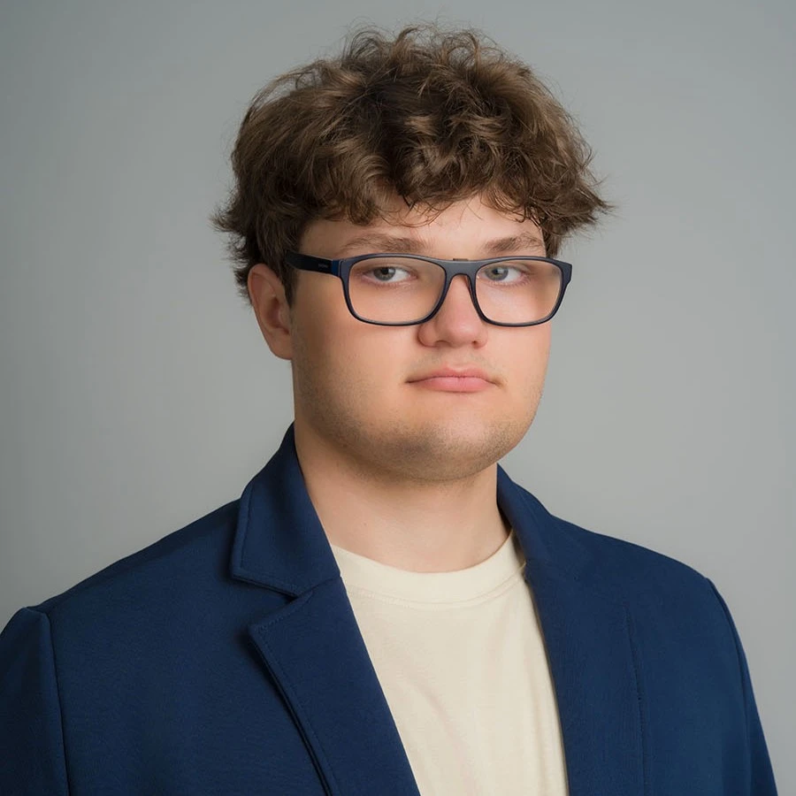 Zdjęcie portretowe Marcina Rezulaka, uśmiechniętego web developera